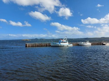 Kıyı taşları ve kayalarla kaplı bir göl manzarası.