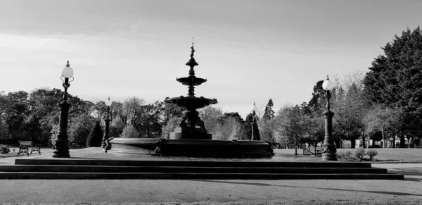 一个灰色比例的带有大喷泉的公园照片 — 图库照片