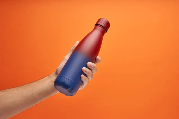 Hand Holding Colorful Thermal Bottle Orange Background — Stock Photo, Image