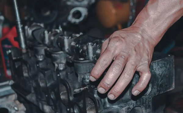 stock image The auto mechanic repairing the engine of a car on the blurred background