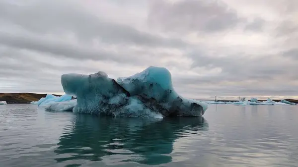 曇った空に向かって水の中に浮かぶ大きな氷山 — ストック写真