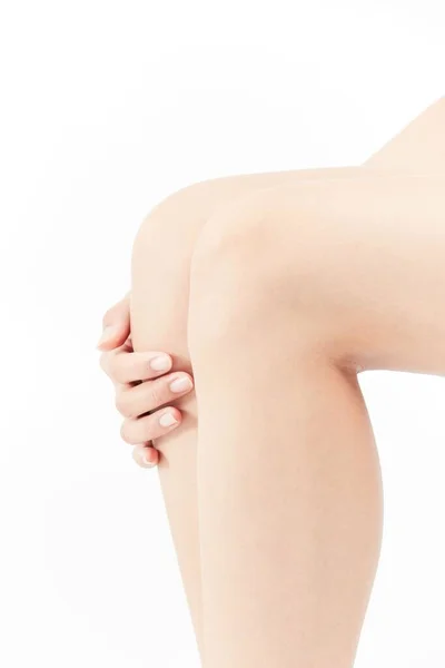 Tiro Vertical Mão Feminina Sobre Pernas Fundo Branco — Fotografia de Stock