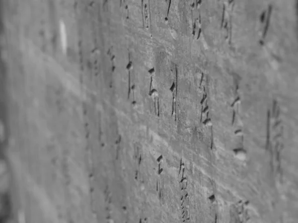 Eine Graustufenaufnahme Der Handschrift Auf Einer Steinmauer — Stockfoto