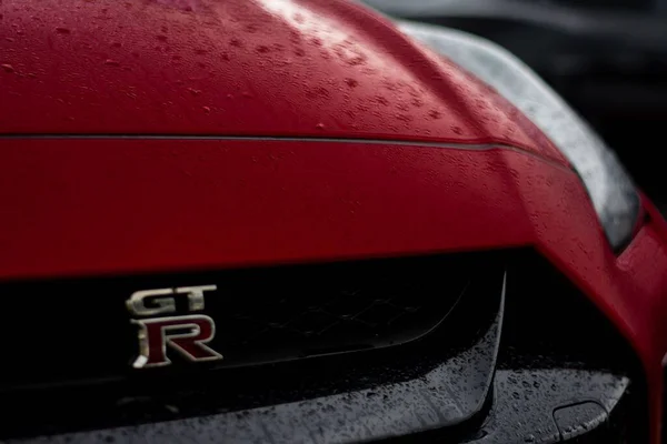 Detailní Záběr Zepředu Logo Mokré Červené Nissan Sportovní Auto Autě — Stock fotografie