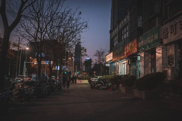 Emberek Sétálnak Közelében Parkoló Kerékpárok Fák Éjszaka Egy Helyi Utcán — Stock Fotó