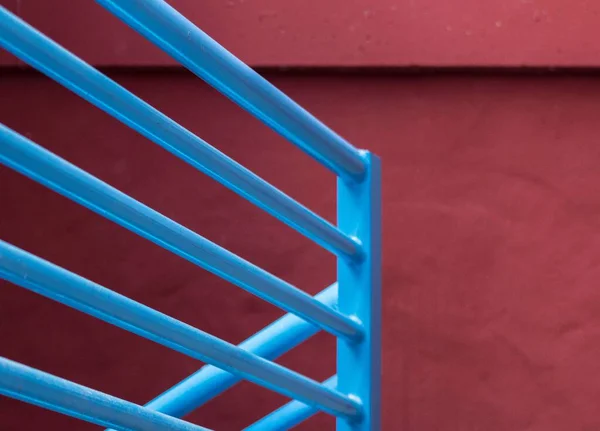 在黑暗的红墙附近的楼梯上的蓝色金属栏杆 — 图库照片
