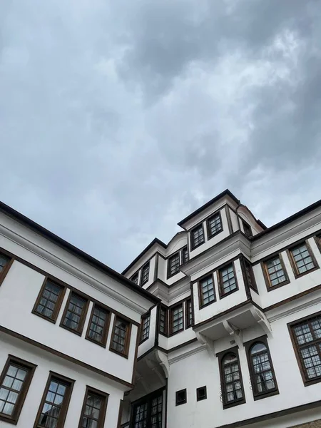 曇り空の下に黒い窓のある近代的な白い建物の垂直低角度ショット — ストック写真