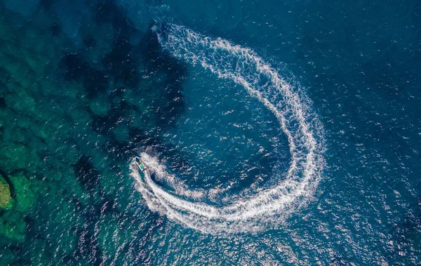 美しいターコイズブルーの海に半円形の水路を残しているモーターボートの空中 — ストック写真