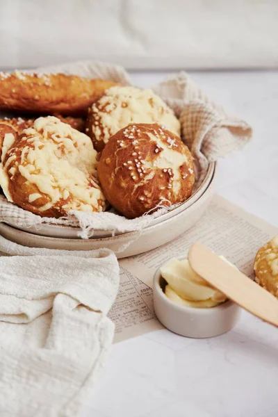 一个由美味的劳根面包与盐和黄油放在白桌上的特写镜头 — 图库照片