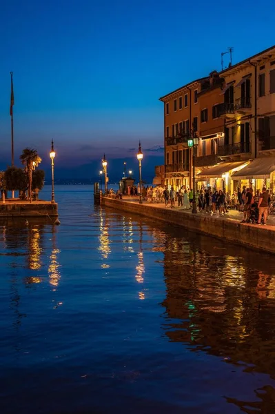 Függőleges Felvétel Garda Tükrözi Városi Fények Épületek Este Lazise Olaszország — Stock Fotó