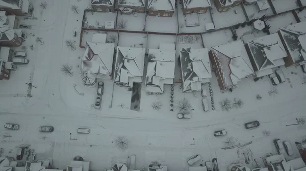 雪に覆われた冬の間にいくつかの家 道路や車のトップビュー — ストック写真