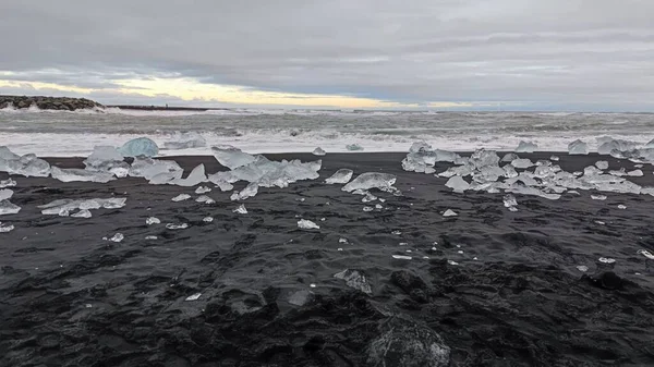 Köpüklü Dalgalar Küçük Buzdağlarıyla Siyah Kumlu Bir Plaja Çarpıyor — Stok fotoğraf