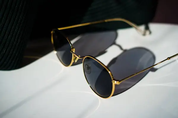 Close Óculos Sol Com Aro Dourado Uma Sombra Queda Mesa — Fotografia de Stock