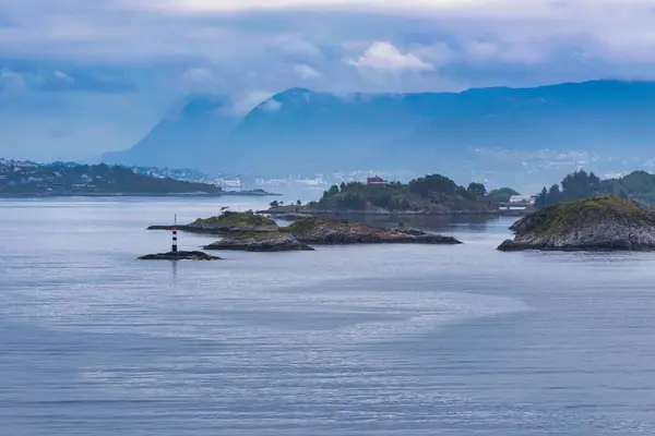 stock image A breathtaking view of a lighthouse on the small island in the sea in Alesund Cruise Port, Norway