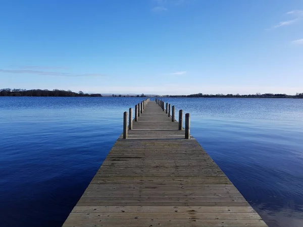 Ein Holzsteg Der Sich Ins Wasser Erstreckt Mit Blauem Himmel — Stockfoto