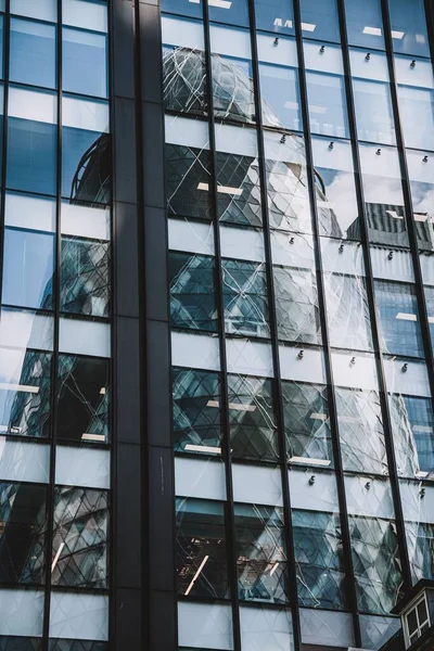 ロンドンのガーキンの建物の垂直ショットは超高層ビルの窓に反映されました — ストック写真