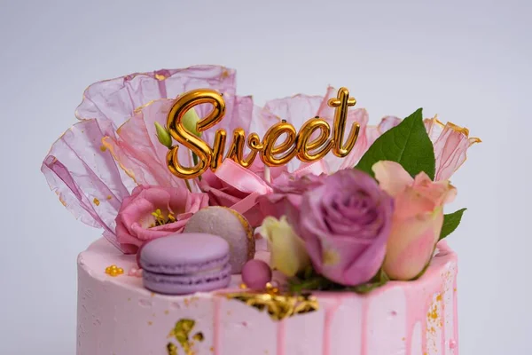一个漂亮的粉色生日蛋糕的特写 上面装饰着金银花 — 图库照片