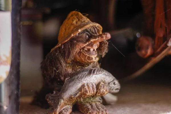 Egy Öreg Trollfigura Kezében Egy Hallal Homályos Háttérrel — Stock Fotó