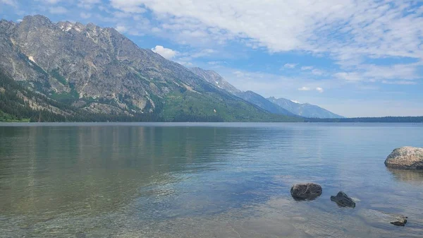 蓝天下湖面透明的风景 背景上有一座小山 — 图库照片