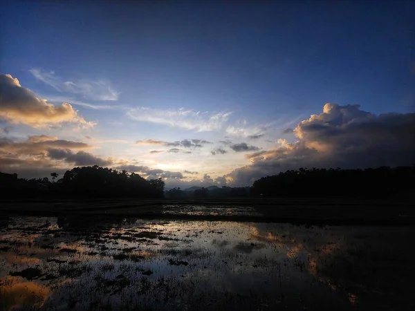 Eine Landschaftliche Aufnahme Von Feldern Und Vegetationssilhouetten Unter Einem Wolkenverhangenen — Stockfoto