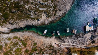 Ada kayalıkları arasındaki turkuaz okyanus suyunda bir tekne anteni.