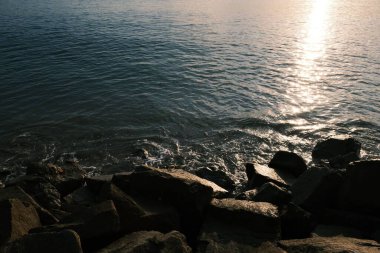 Güneşin kıyıdaki suyu yansıtan yüksek açılı görüntüsü.