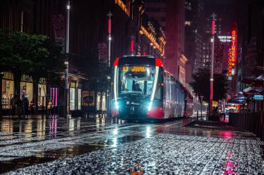 Yağmurlu bir gecede George Caddesi 'nin ortasında gezinen bir tramvayın uzun pozlu görüntüsü.