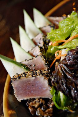 Ton balığı ve sebzeli Asya salatasının dikey yakın çekimi.