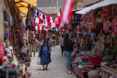 Cusco, Peru 'da renkli kıyafetlerle geleneksel bir marketten alışveriş yapıyor.