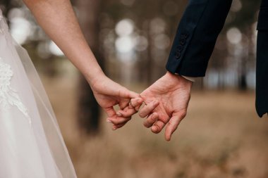 Düğün töreni sırasında el ele tutuşan bir çift.