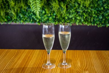 A closeup shot of two glasses of prosecco placed on a wooden table clipart