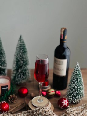Noel temalı bir köşede bir kadeh şarabın dikey yakın çekimi.