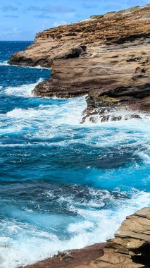 Okyanus dalgalarının Lanai Gözcüsü, Oahu, Hawaii 'deki kayalıklara çarptığı dikey bir görüntü.