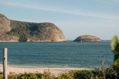 Güzel bir boş sahil sahili ve dağın yakınındaki denizde kayıklar.