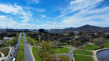 Mavi bulutlu gökyüzünün altındaki parkın yakınındaki otoyolların kuş bakışı görüntüsü.