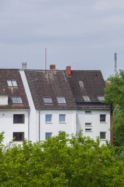 Bremen 'deki yeşil ağaçlarla çevrili eski konutların dikey görüntüsü