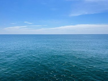 Gün boyunca mavi gökyüzünün altında güzel bir deniz manzarası.