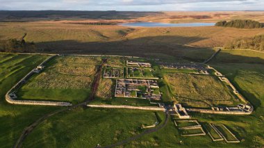 Hadrian 'ın Duvarı' ndaki, Northumberland, İngiltere 'de yeşil bir tarlanın ortasında bulunan Housesteads Roma Kalesi' ndeki yedek kalenin hava görüntüsü.