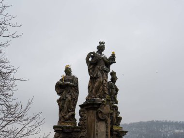 Bulutlu bir gökyüzünün altında düşük açılı heykeller.