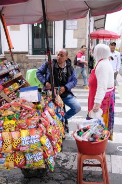 Sokaklarda abur cubur ve içki satan bir satıcının dikey görüntüsü.