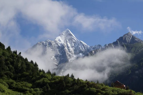 Мальовничий Знімок Гострих Гірських Вершин Вкритих Снігом Оточений Хмарами Зеленими — стокове фото