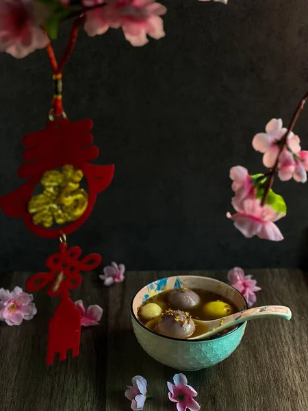 ピンクの花で飾られたテーブルの上にTangyuanのボウルの垂直閉鎖 — ストック写真