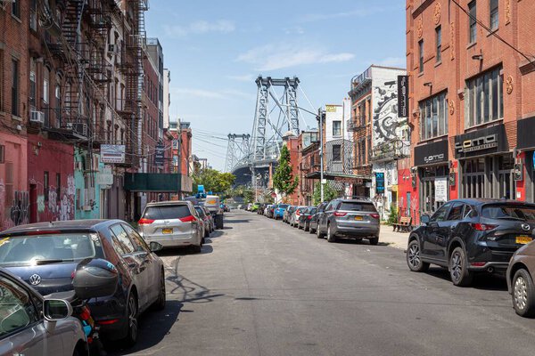 View along a side street in Williamsburg, New York, with the Williamsburg Bridge in the backg