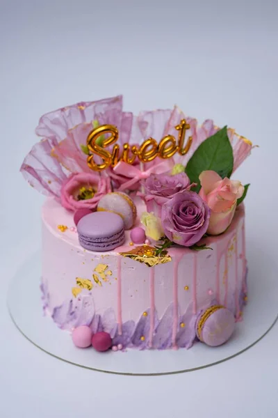マカロンと花で装飾された美しいピンク色の誕生日ケーキのクローズアップ — ストック写真