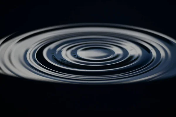 Eine Nahaufnahme Von Wasser Plätschert Auf Einer Dunklen Oberfläche — Stockfoto
