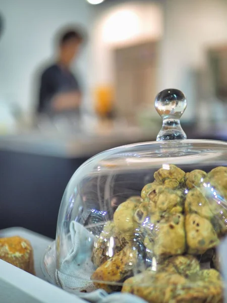 イタリア料理店で展示されているガラス瓶の中の焼きトリュフの垂直クローズアップショット — ストック写真