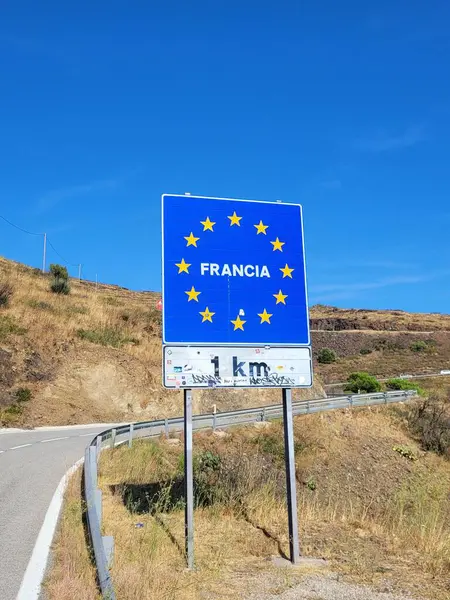A vertical shot of France road sign on the roadside under blue sky