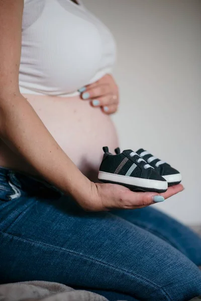 Female Holding Pair Sneakers Front Her Belly — Stock Photo, Image
