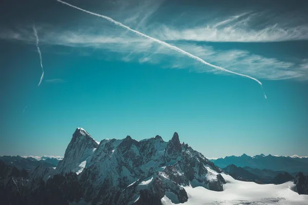 Flygbild Ett Stenigt Berg Täckt Snö Himlen Och Flygplansspår — Stockfoto