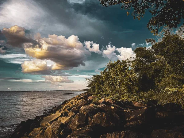 Vacker Blå Himmel Med Ljusa Gyllene Moln Över Klippiga Stranden — Stockfoto